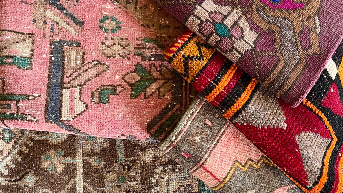 Close-up of patterned rugs with intricate designs on a textured surface.